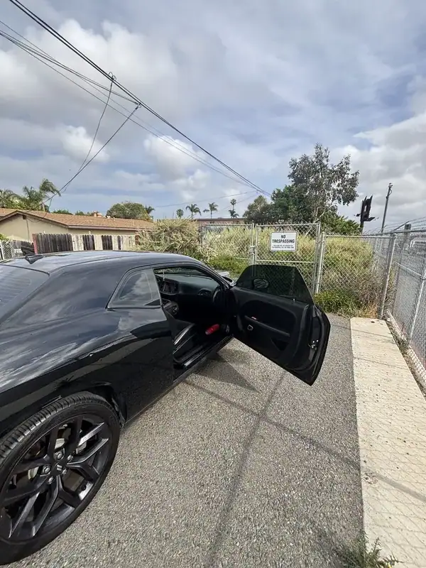 Black Dodge Challenger HEMI side profile from rear with ceramic window tint completed on-site — San Diego mobile auto window tinting