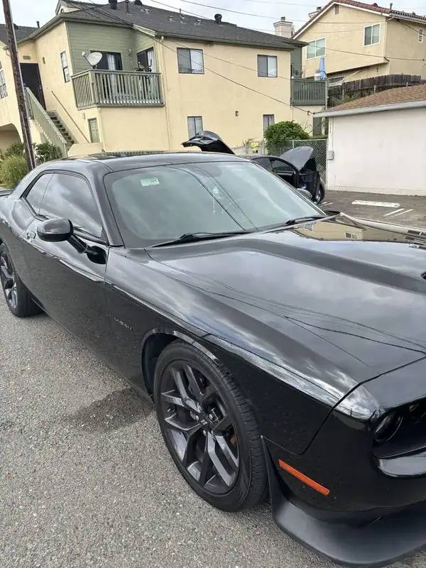 Black Dodge Challenger R/T HEMI passenger side close-up showing dark ceramic IR window tint and dark wheels — mobile window tinting San Diego
