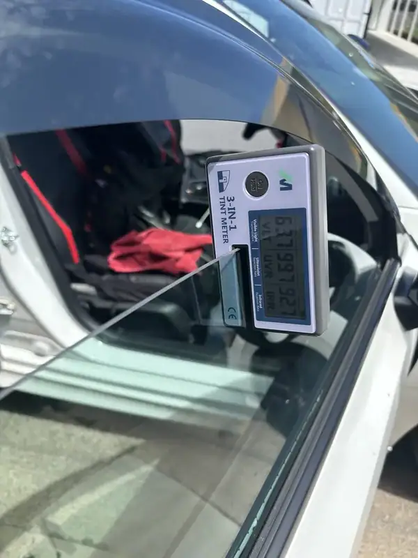 3-in-1 tint meter on Honda Civic front window reading 63% VLT, 99% UV rejection, 92% IR rejection — proof of HiTek 70% ceramic IR film performance