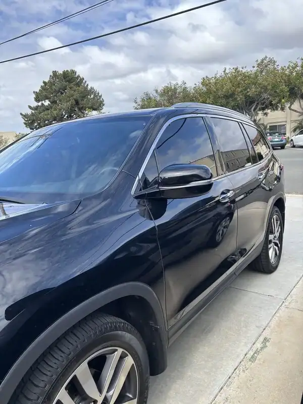 2017 Honda Pilot Touring driver-side profile showing front and rear doors with freshly installed ceramic IR window tint matched to factory privacy glass — mobile window tinting San Diego