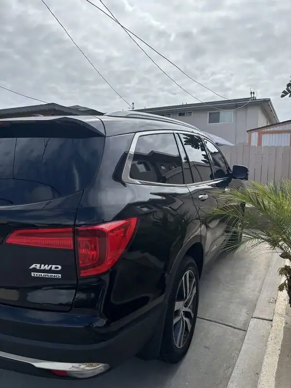2017 Honda Pilot Touring AWD rear passenger side close-up showing AWD TOURING badge and ceramic IR tint on rear door and quarter glass — mobile window tint San Diego