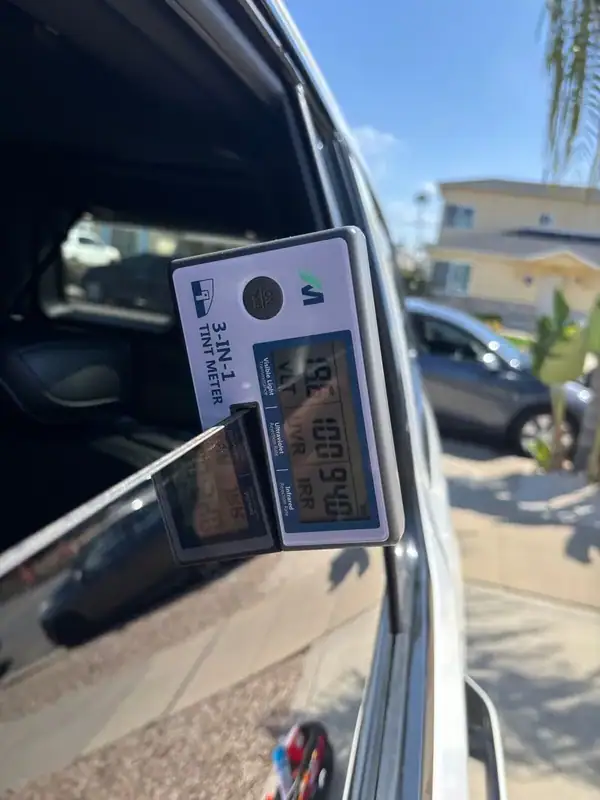 BestAutoTechs 3-in-1 tint meter on Jeep Wagoneer rear passenger glass showing high IR heat rejection and 100% UV rejection on HiTek ceramic IR film — verified on-site in San Diego