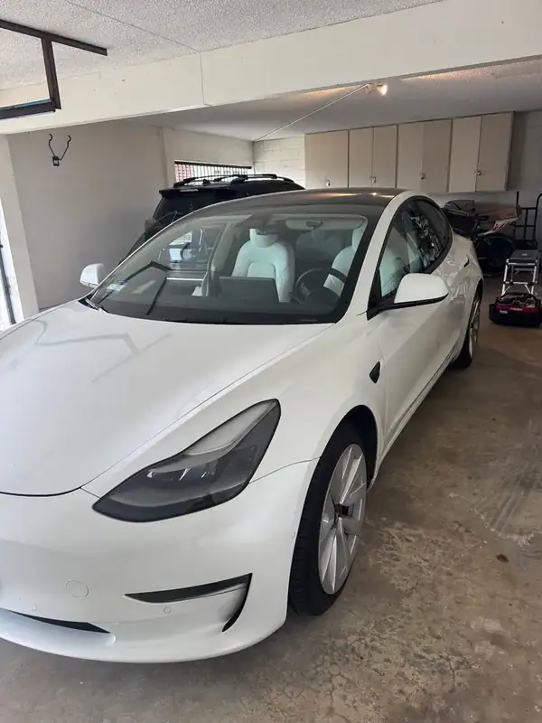 Tesla Model 3 front quarter view in garage with ceramic window tint — mobile tinting San Diego
