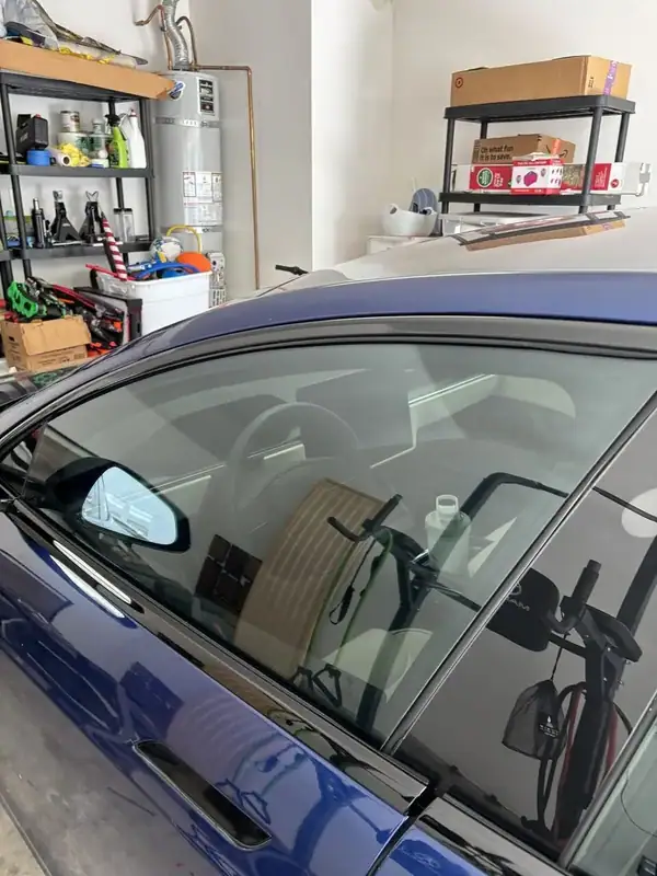 2021 Tesla Model S Plaid front passenger window with yoke steering wheel and dashboard visible after ceramic window tint install — mobile EV window tinting San Diego