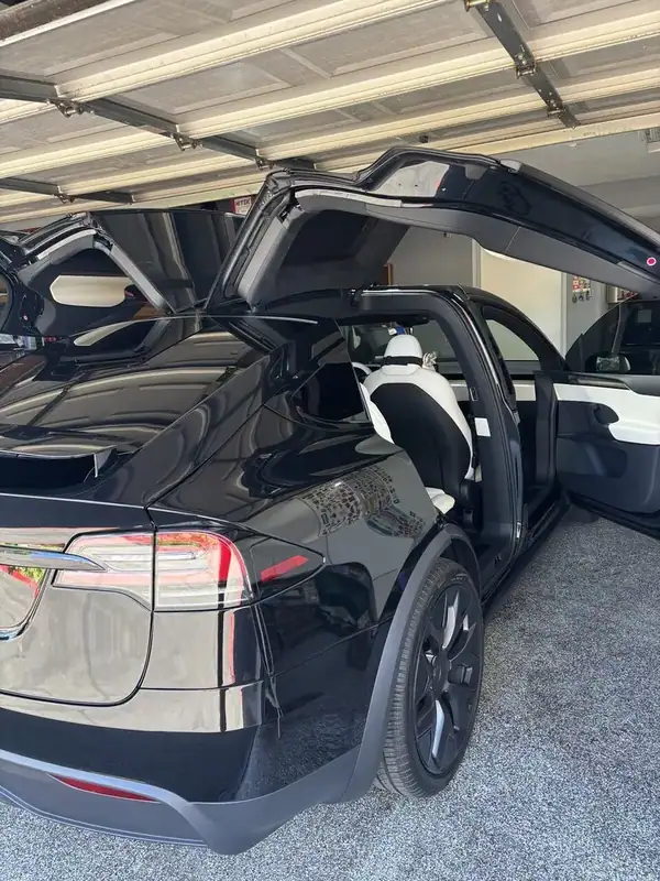 Black Tesla Model X with falcon-wing doors open showing ceramic window tint on rear glass — mobile window tinting San Diego