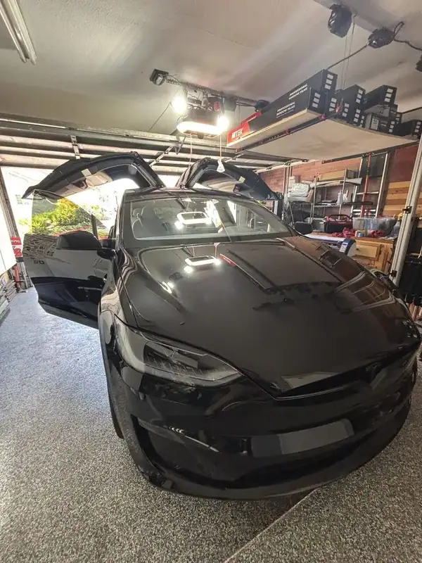 Black Tesla Model X in shop with HiTek professional window films during ceramic IR tint install — San Diego mobile EV window tinting