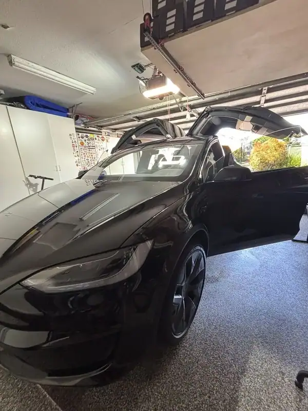 Black Tesla Model X front quarter close-up showing 20-inch wheels and dark ceramic IR tint — mobile window tinting San Diego