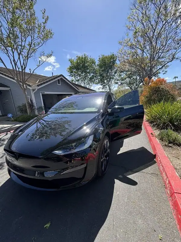 Black Tesla Model X driver door open after ceramic window tint installation completed on-site — BestAutoTechs San Diego mobile