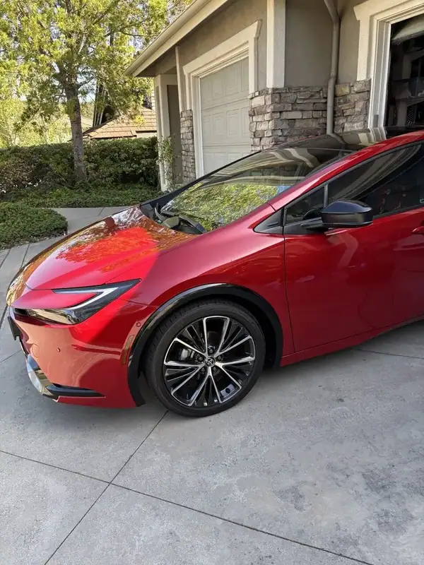 Red Toyota Prius Limited front quarter close-up showing 19-inch wheels and tinted windows — mobile window tinting San Diego
