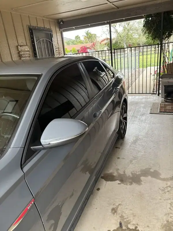 Volkswagen Jetta GLI passenger side showing dark ceramic tint on side glass — mobile window tinting San Diego
